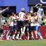 ras una jugada de pelota quieta, el defensor Sergiño Dest ensayó un potente derechazo desde la frontal del área penal; el disparo se desvió y generó una parábola que el juvenil lateral Alex Freeman capitalizó en el área chica al conectar un impecable testarazo ante la salida tardía del arquero Patrick Beach, decretando el cómodo 2-0 - Foto: X/@USMNT