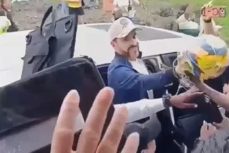 Videos difundidos en redes sociales muestran al presidente desde una camioneta, acompañado por su esquema de seguridad, mientras entrega o lanza balones a niños y habitantes de la zona. En los implementos aparece el nombre del movimiento político que llevó a De la Espriella a la Presidencia - Foto: Captura Vídeo