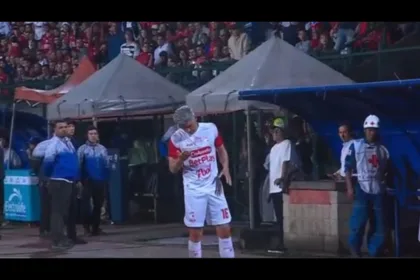 Uno de esos objetos fue una moneda que alcanzó el rostro del jugador de Santa Fe. El impacto le produjo una herida y provocó sangrado, por lo que Torres tuvo que recibir atención del cuerpo médico del conjunto capitalino antes de poder continuar hacia el banco - Foto: Captura Vídeo Win Sports